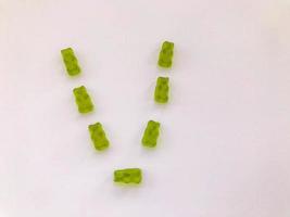 creatief eetbaar brief v gemaakt van kleverig beren. brief gemaakt van groen gelatineachtig en smakelijk snoepjes. calorierijk nagerecht, heerlijk creatief alfabet. woord studie foto