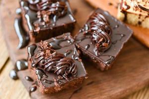 taart chocola saus heerlijk toetje geserveerd Aan de tafel - taart plak Aan houten snijdend bord achtergrond met topping chocola foto