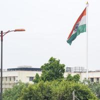 indiase vlag hoog op connaught plaats met trots in blauwe lucht, indiase vlag wapperen, indiase vlag op onafhankelijkheidsdag en republiek dag van india, tilt-up shot, wuivende indische vlag, har ghar tiranga foto