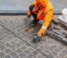 dnjepropetrovsk, Oekraïne - 02.10.2022 een mannetje arbeider reparaties de bestrating met een drilboor. de werk van de gemeentelijk onderhoud. foto