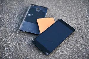 beschadigd smartphone met gebroken tintje scherm Aan asfalt foto