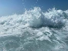 mooi zee met golven spatten warm sprankelend Doorzichtig blauw water in een warm tropisch oosters land zuidelijk toevlucht. achtergrond, structuur foto