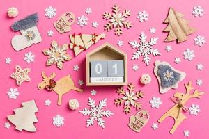 top visie van kalender Aan roze achtergrond gemaakt van vakantie decoraties en speelgoed. Kerstmis ornament concept foto