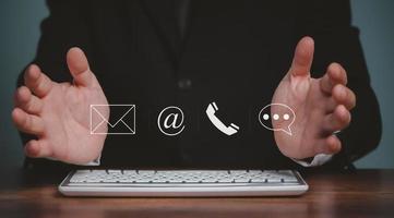 contact ons, hand- van zakenman gebruik makend van computer en Holding post, telefoon, e-mail, babbelen pictogrammen. bedrijf cutomer ondersteuning en onderhoud concept, kopiëren ruimte. foto