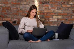 echt vrouw werken Aan een laptop met notitieboekje en wit kop terzijde foto