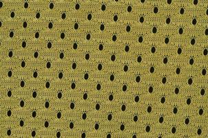 achtergrond beeld van een kleding stof structuur van een geel Jersey gemaakt van polyester nylon. macro foto met Ondiep diepte van veld-