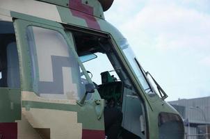 helikopter cabine fragment dichtbij omhoog. camouflage vliegtuig romp en kogelvrij glas foto