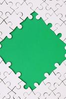 framing in de het formulier van een ruit, gemaakt van een wit decoupeerzaag puzzel in de omgeving van de groen ruimte foto