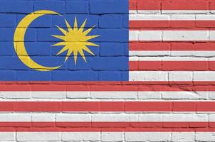 Maleisië vlag afgebeeld in verf kleuren Aan oud steen muur. getextureerde banier Aan groot steen muur metselwerk achtergrond foto