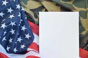 blanco papier leugens Aan Verenigde staten van Amerika vlag en gevouwen leger uniform jasje. leger symbolen conceptuele achtergrond banier en kopiëren ruimte foto