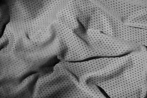 grijs sport kleding kleding stof structuur achtergrond. top visie van grijs kleding textiel oppervlak. donker basketbal shirt. foto
