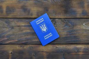 foto van de oekraïens buitenlands paspoort, aan het liegen Aan een donker houten oppervlak. de concept van introduceren visumvrij reizen voor oekraïens burgers