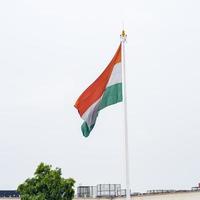 indiase vlag hoog op connaught plaats met trots in blauwe lucht, indiase vlag wapperen, indiase vlag op onafhankelijkheidsdag en republiek dag van india, tilt-up shot, wuivende indische vlag, har ghar tiranga foto