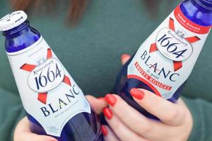 Charkov, Oekraïne - mei 3, 2021 jong meisje houdt 1664 kronenbourg blanc bier glas buitenshuis. 1664 blanc is de tarwe bier van de Frans brouwerij kronenbourg geëxporteerd wereldwijd foto