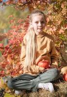 meisje in de hooi met pompoenen foto