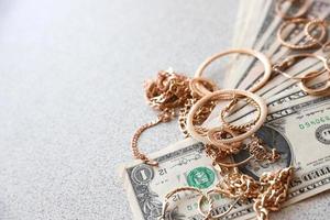 veel duur gouden jewerly ringen, oorbellen en kettingen met groot bedrag van ons dollar rekeningen met kopiëren ruimte. pandjeshuis of jewerly winkel foto