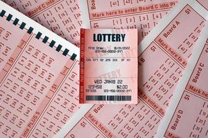 rood loterij ticket leugens Aan roze het gokken lakens met getallen voor markering naar Speel loterij. loterij spelen concept of het gokken verslaving. dichtbij omhoog foto