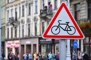 een weg teken met een afbeelding van een fiets tegen een druk straat. wielersport toegestaan foto