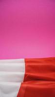 gevouwen vlag van Polen Aan levendig roze achtergrond foto