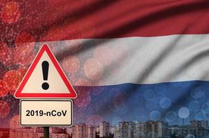 Nederland vlag en coronavirus 2019-ncov alarm teken. concept van hoog waarschijnlijkheid van roman coronavirus het uitbreken door op reis toeristen foto