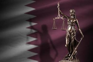 qatar vlag met standbeeld van dame gerechtigheid en gerechtelijk balans in donker kamer. concept van oordeel en straf foto