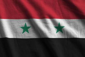 Syrië vlag met groot vouwen golvend dichtbij omhoog onder de studio licht binnenshuis. de officieel symbolen en kleuren in banier foto