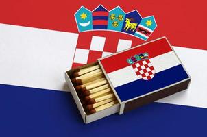 Kroatië vlag is getoond in een Open luciferdoosje, welke is gevulde met wedstrijden en leugens Aan een groot vlag foto