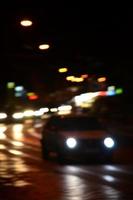 wazig nacht tafereel van verkeer Aan de rijweg. onscherp beeld van auto's op reis met lichtgevend koplampen. bokeh kunst foto