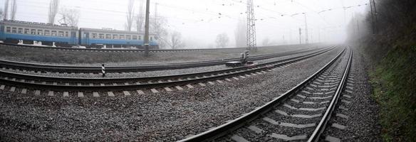 de oekraïens buitenwijk trein haast langs de spoorweg in een nevelig ochtend. vissenoog foto met is gestegen vervorming