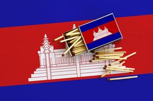 Cambodja vlag is getoond Aan een Open luciferdoosje, van welke meerdere wedstrijden vallen en leugens Aan een groot vlag foto