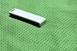een modern portable USB Wifi adapter is geplaatst Aan de groen sportkleding gemaakt van polyester nylon- vezel foto