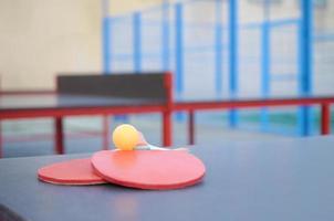 rackets en bal Aan ping pong tafel in buitenshuis sport tuin. actief sport- en fysiek opleiding concept foto