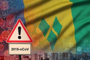 heilige vincent en de grenadines vlag en coronavirus 2019-ncov alarm teken. concept van hoog waarschijnlijkheid van roman coronavirus het uitbreken door op reis toeristen foto