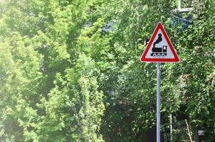 driehoekig weg teken met een afbeelding van een zwart locomotief Aan een wit achtergrond in een rood kader. waarschuwing teken voor de aanwezigheid van een spoorweg kruispunt de motor weg foto