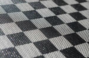 plastic structuur in de het formulier van een heel klein kleding verbindend, geschilderd in zwart en grijs in de stijl van een schaakbord. macro schot foto