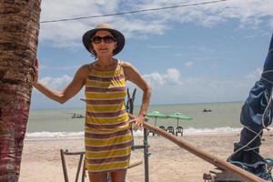 dame Bij de strand in kam, Brazilië, staand tegen een palm boom foto