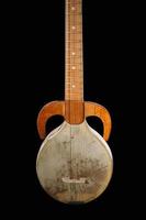 een oude Aziatisch geregen musical instrument Aan een zwart achtergrond foto