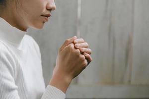 vrouw bidden voor godzijdank bidden met haar handen samen om te denken aan een liefhebbende god, we prijzen god met lichte gloed in de groene natuur. foto
