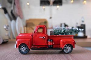 een rood retro auto met een Kerstmis boom siert de feestelijk keuken voor kerstmis. huis decor, feestelijk stemming, nieuw jaar foto