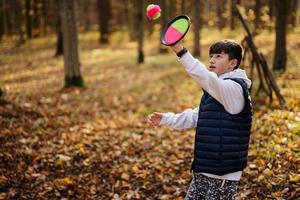 herfst buitenshuis portret van jongen Speel met vangst en toss bal spel. foto