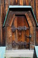 oud verweerd deur in de houten muur van een oude hut foto