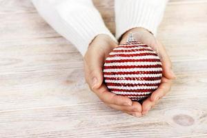 Kerstmis boom speelgoed- in de handen van een Dames. nieuw jaar. kerstmis. houten achtergrond foto