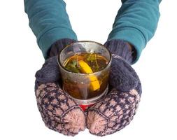 vrouw handen in wanten, Holding een oud glas met thee. foto