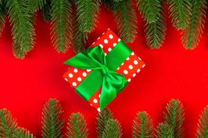 top visie van geschenk doos en Spar boom takken Aan kleurrijk achtergrond. vrolijk Kerstmis concept met leeg ruimte voor uw ontwerp foto