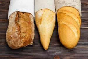 eigengemaakt stokbrood Aan houten tafel. dichtbij omhoog foto