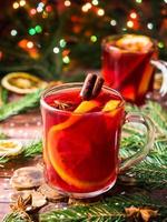 Kerstmis overwogen wijn met sinaasappels en specerijen Kerstmis decoraties met bokeh foto