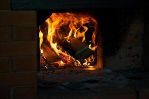 kam van vlam Aan brandend hout in haard. brandend brandhout in een Russisch fornuis. foto