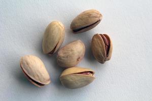 pistache in schelp noten in een kom Aan wit achtergrond. foto