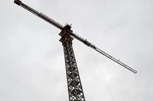 groot krachtig bouw lading industrieel kraan Aan een bouw plaats van nieuw gebouwen en huizen tegen de lucht foto