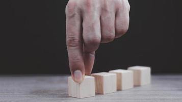 hand- regelen van hout blok stapelen net zo stap trap Aan houten tafel. bedrijf concept voor groei succes werkwijze. kopiëren ruimte foto